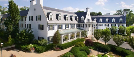 A large, white building with multiple windows and a covered walkway.