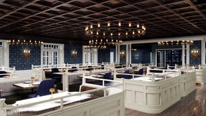 A restaurant with high ceilings, patterned walls, and multiple seating areas.
