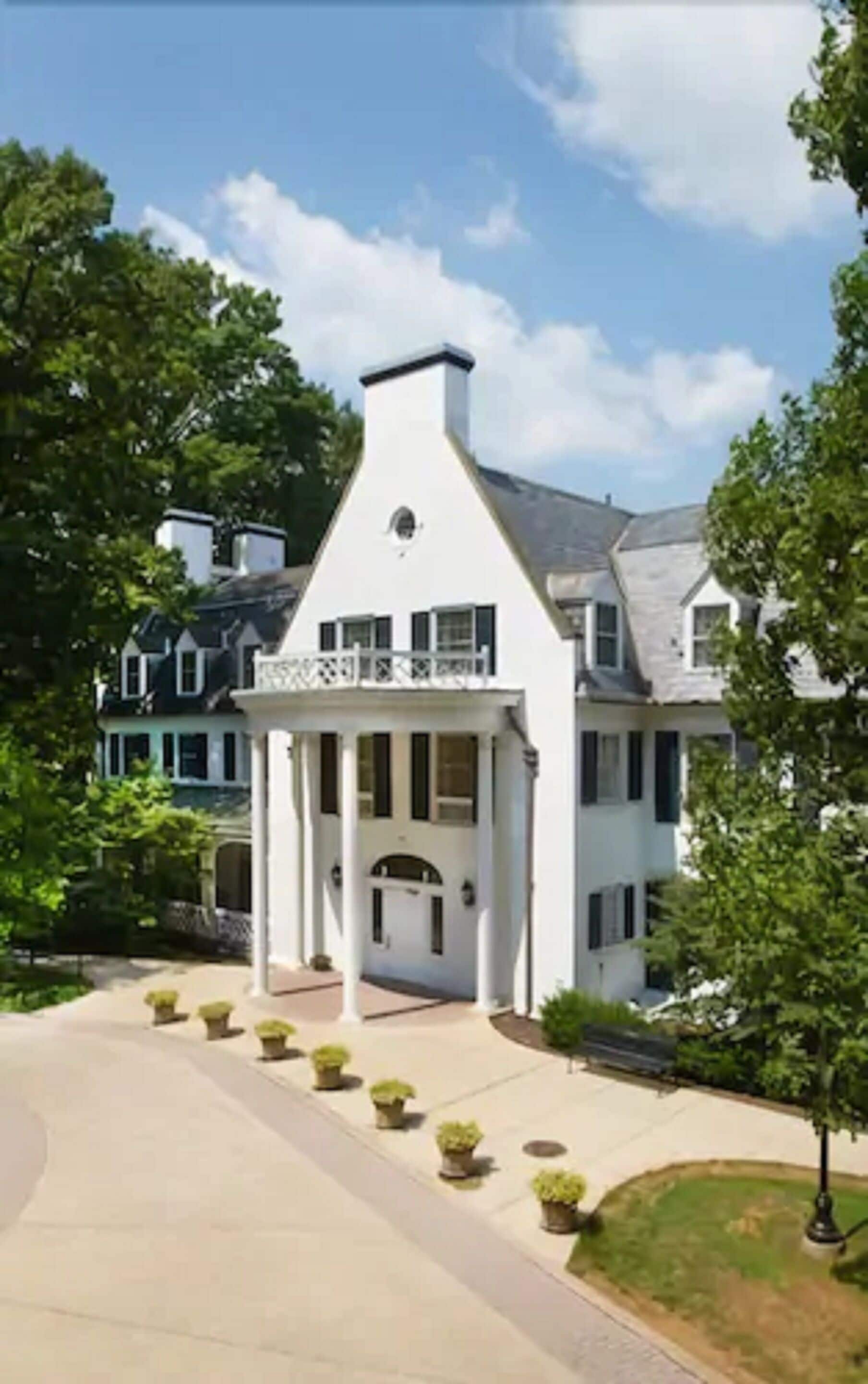 A large, white building with a central entrance and a covered porch.