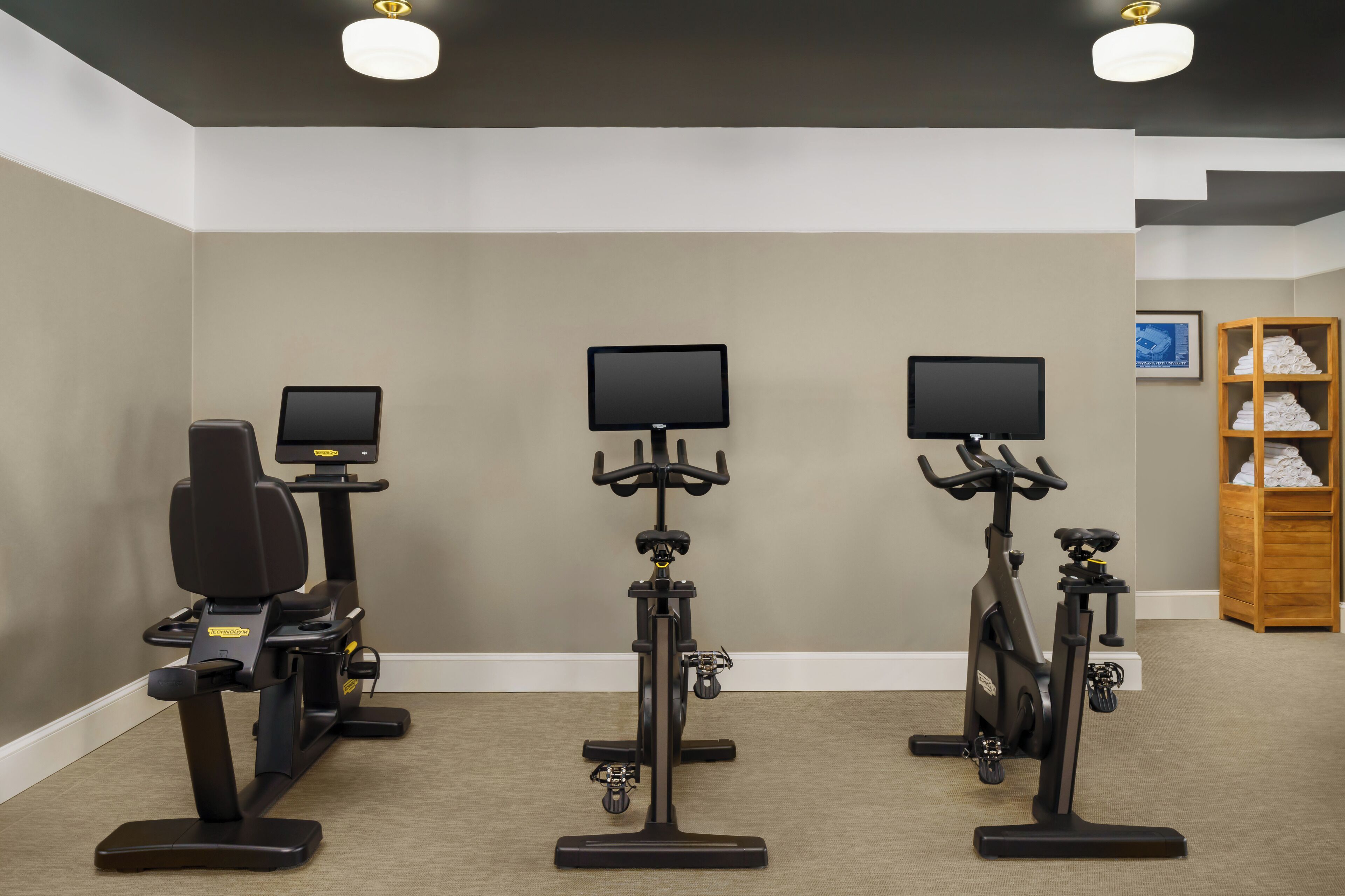 Une salle de remise en forme équipée de vélos d’appartement, chacun étant doté d’un écran.