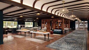 A spacious library with wooden bookshelves, a fireplace, and a large rug.