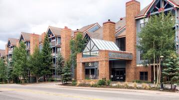 Un hôtel à la façade en briques, doté de nombreuses cheminées et d’une enseigne indiquant qu’il s’agit du « Mountain Lodge ».