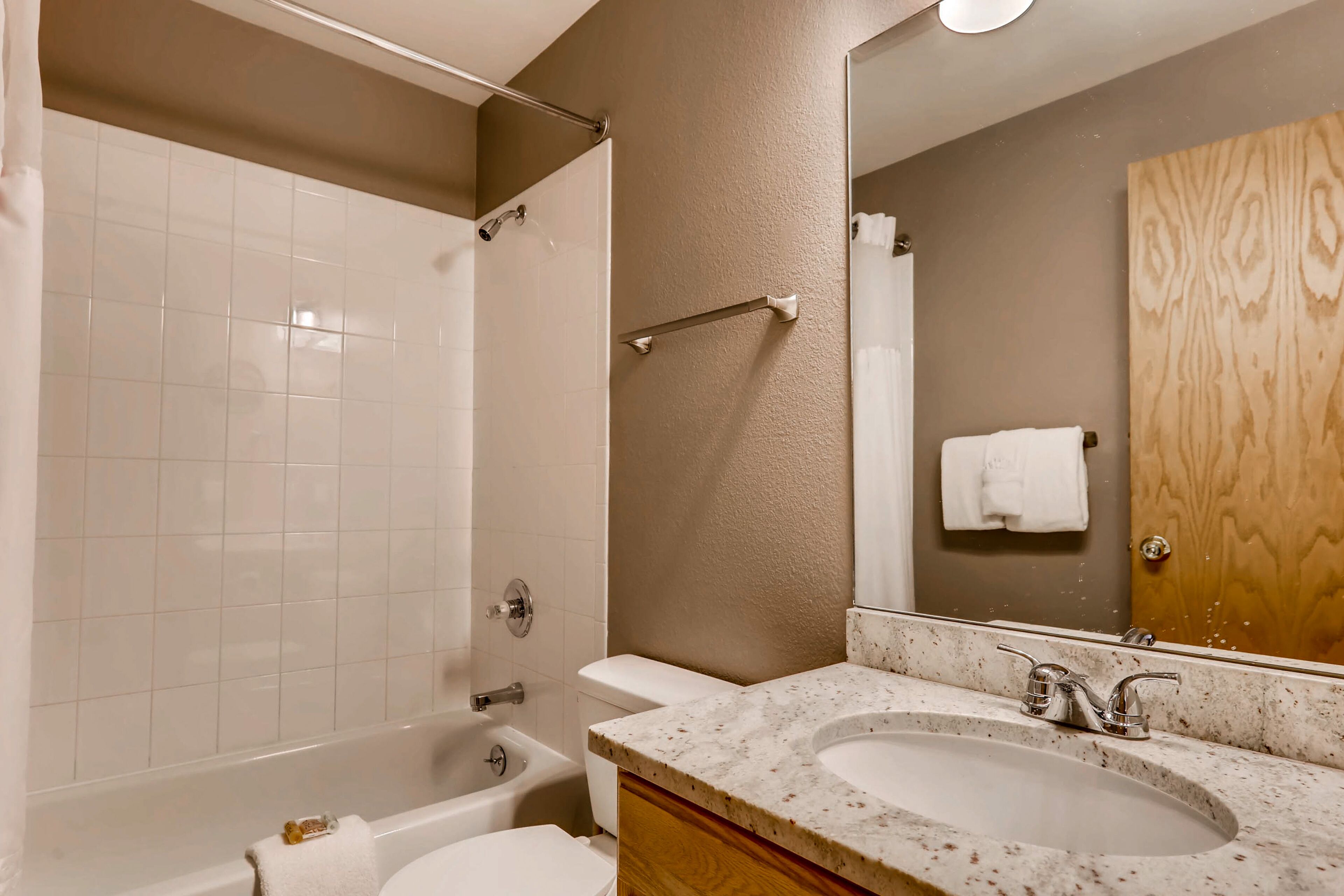 A bathroom with a bathtub, toilet, and sink.