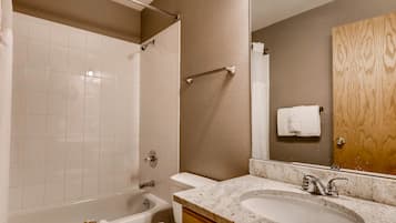 A bathroom with a bathtub, toilet, and sink.