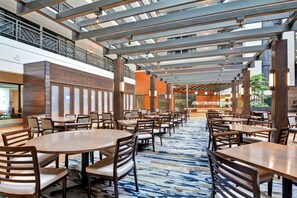 Enjoy meals in a spacious dining area with high ceilings and pendant lights.