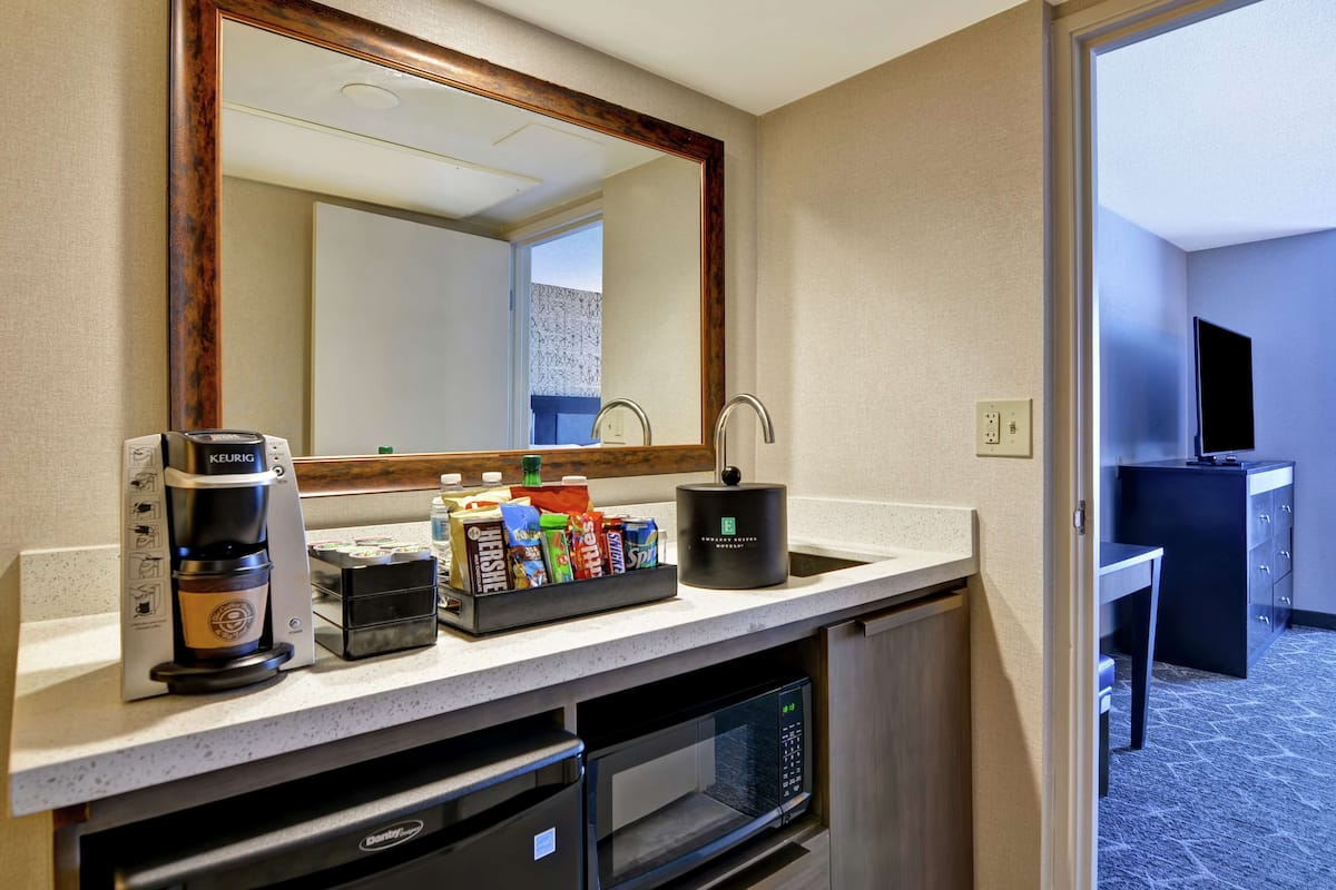 Una cuina d'hotel equipada amb cafetera, microones i un espai per a begudes diverses.