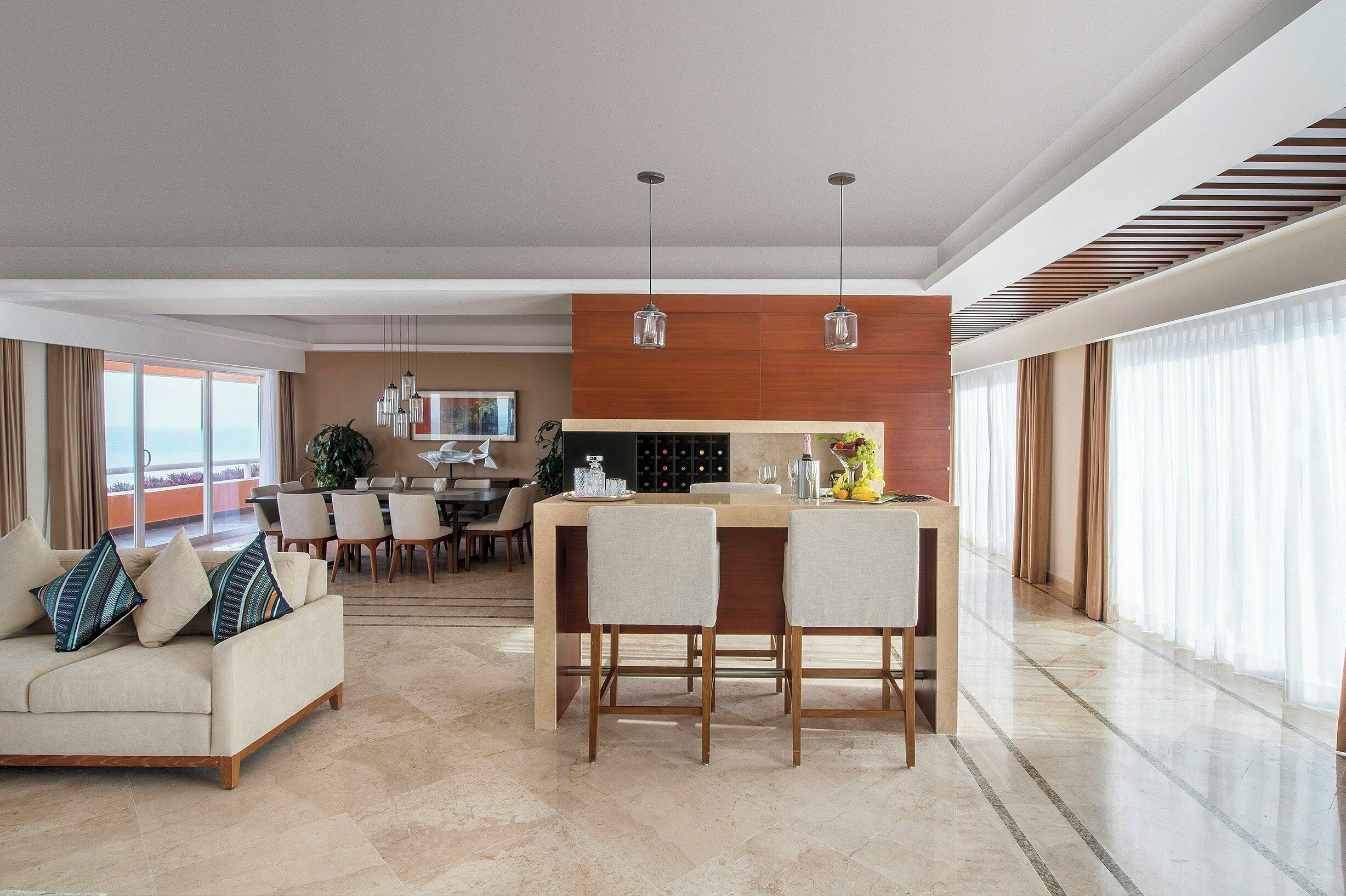 Una sala de estar moderna con sofá, comedor y cocina.