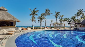 Una piscina cubierta, una piscina al aire libre, sombrillas, tumbonas