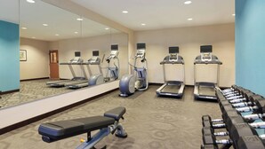 A gym with treadmills, elliptical machines, a bench, and dumbbells. - Fairfield Inn & Suites Colorado Springs Air Force Academy (Colorado Springs)