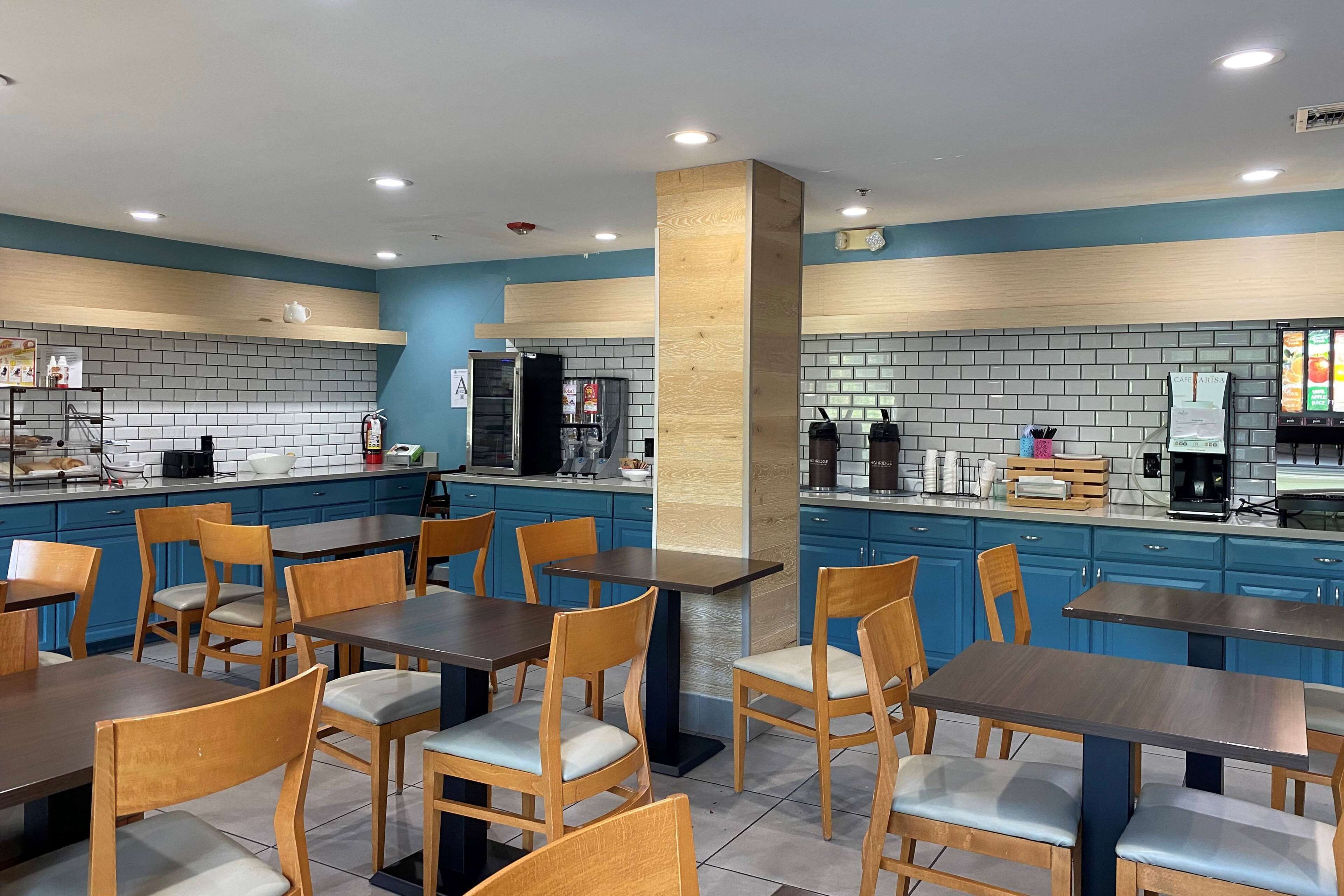 Un café moderne avec des meubles bleus, des tables et des chaises en bois.