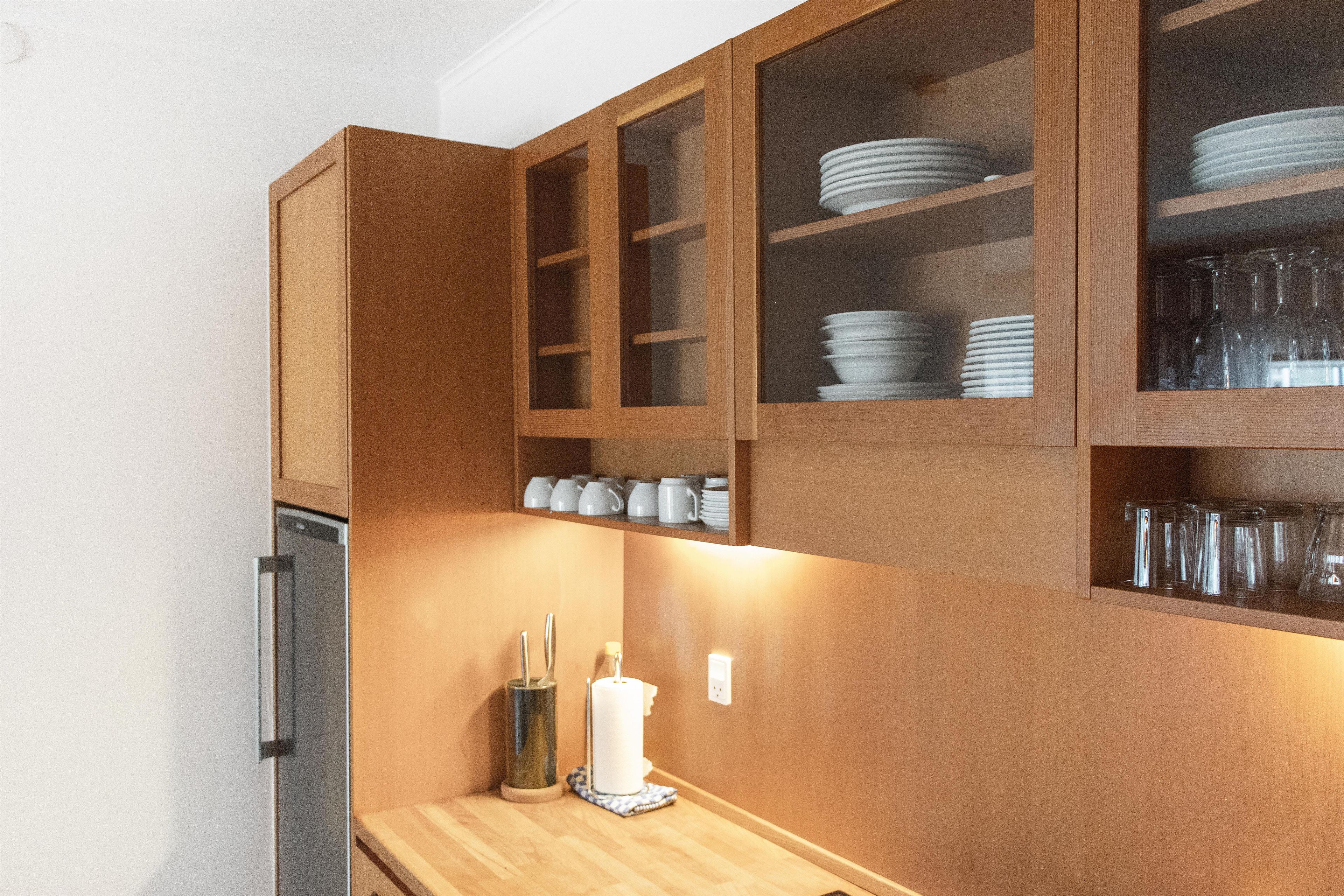 Una cocina con armarios de madera, una encimera y una vela encendida.