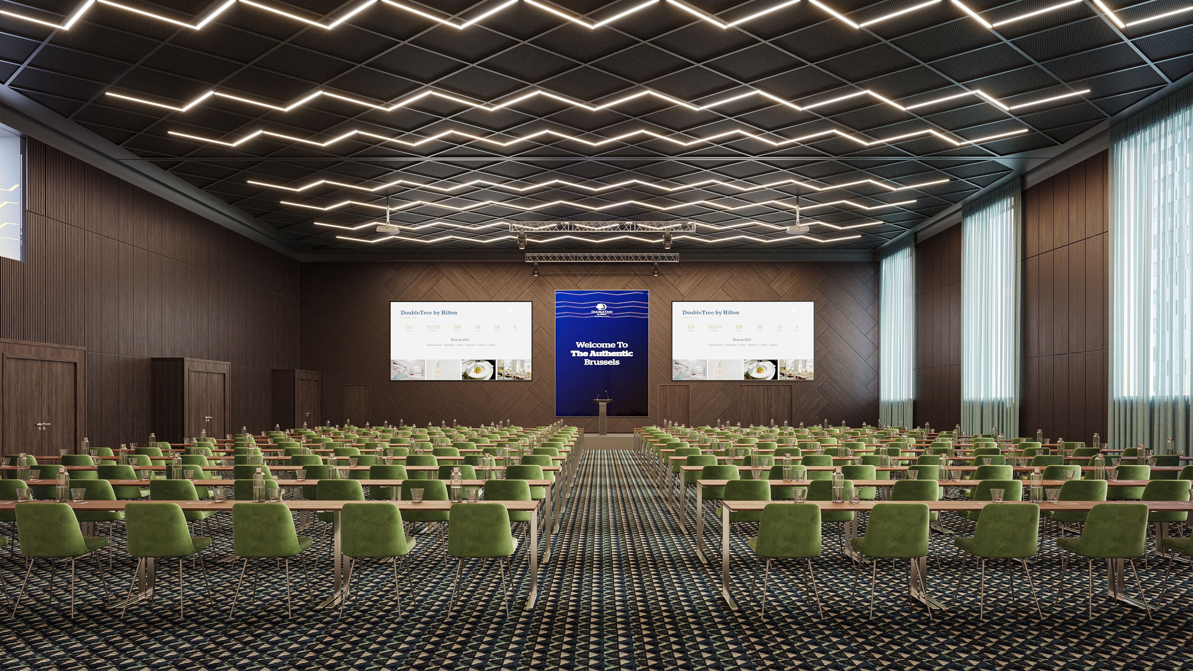 A conference room with green chairs, a patterned carpet, and a modern ceiling design.