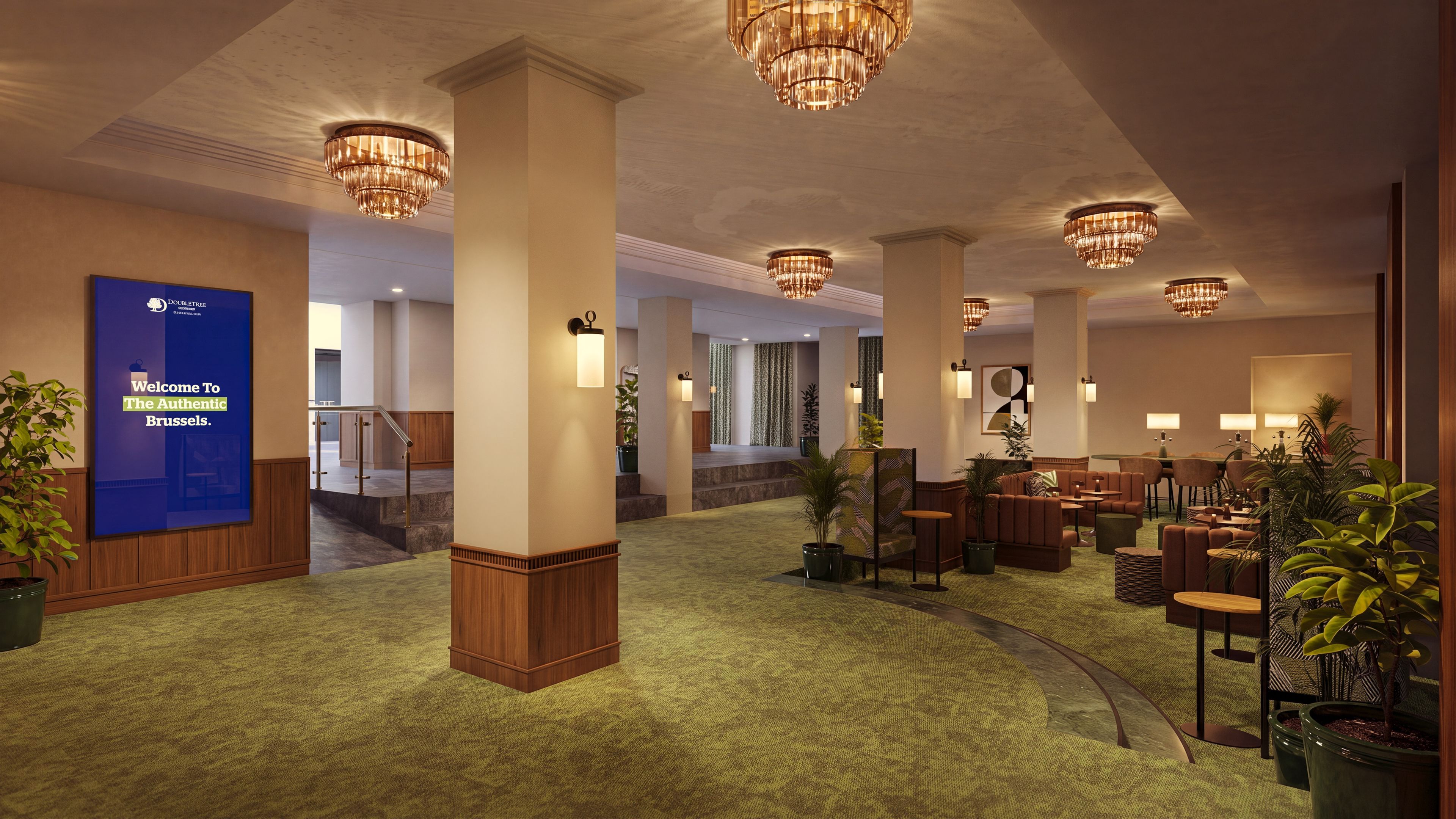A hotel lobby with a reception desk, seating area, and a staircase leading to other floors.