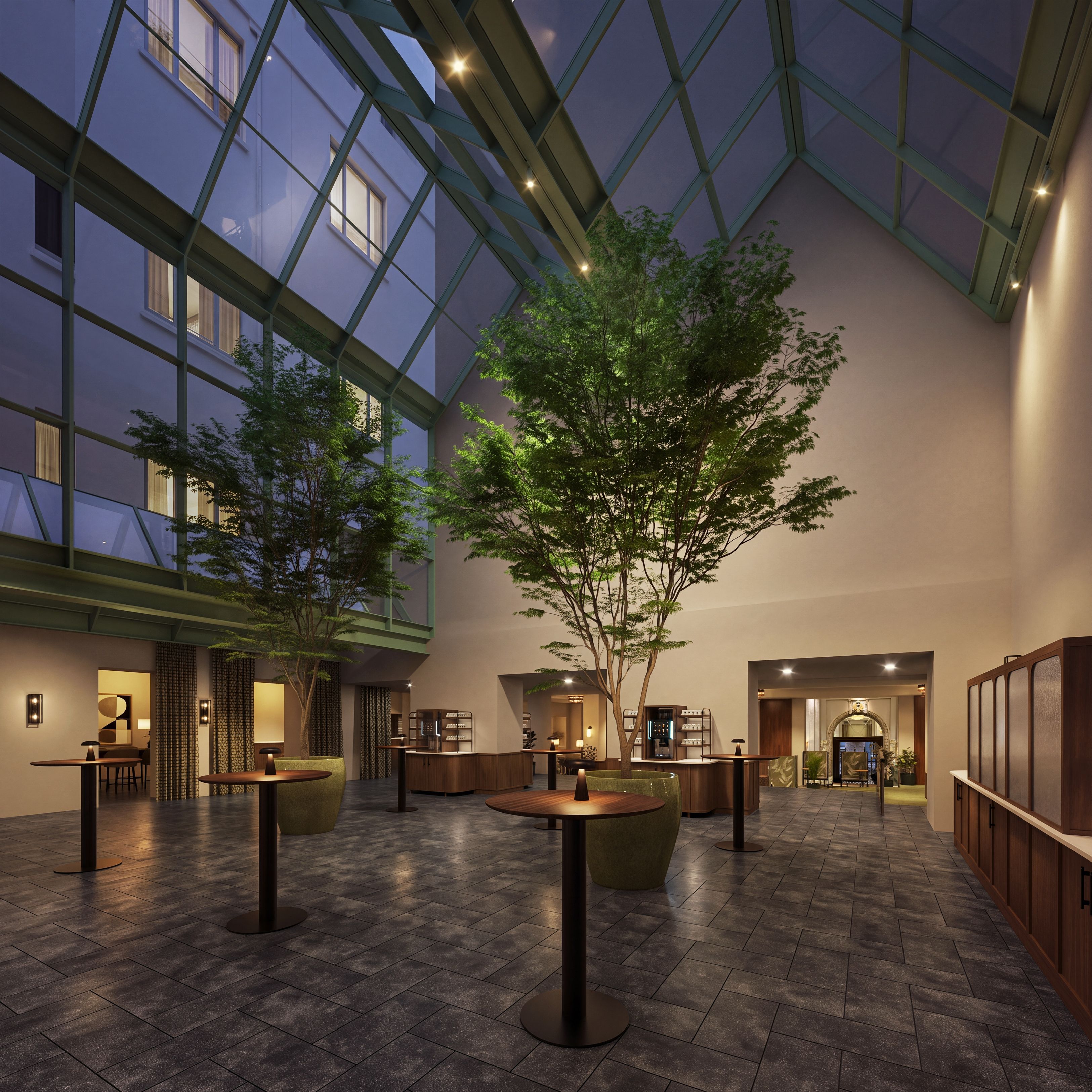 A spacious indoor area with a high ceiling, large windows, and a central tree.