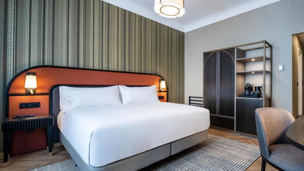 Sengetøy av topp kvalitet, dundyner, minibar og safe på rommet