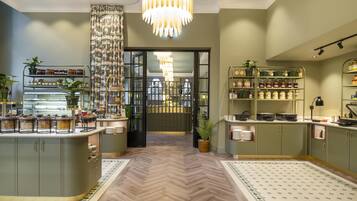 A modern kitchen with a herringbone floor, open shelving with jars, and a central island.