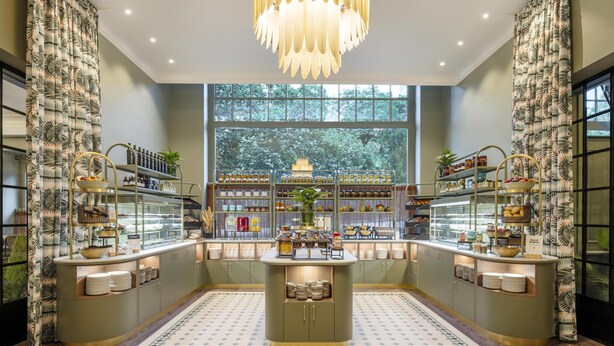 A modern kitchen with a central island, built-in shelves, and a large window offering a view of the outdoors. - DoubleTree by Hilton Brussels City (Brussels)