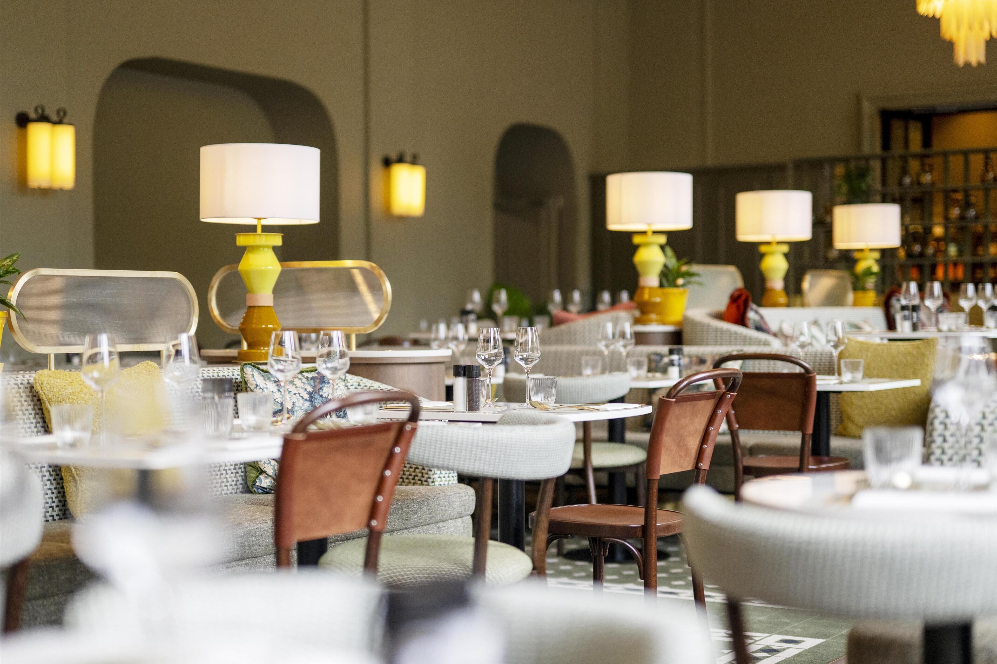 Ein Restaurant mit runden Tischen, Stühlen und Lampen.