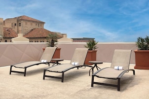 Una piscina al aire libre, sillones reclinables de piscina