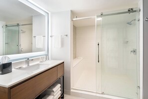 Een bad/douchecombinatie, een regendouche, designer toiletartikelen
