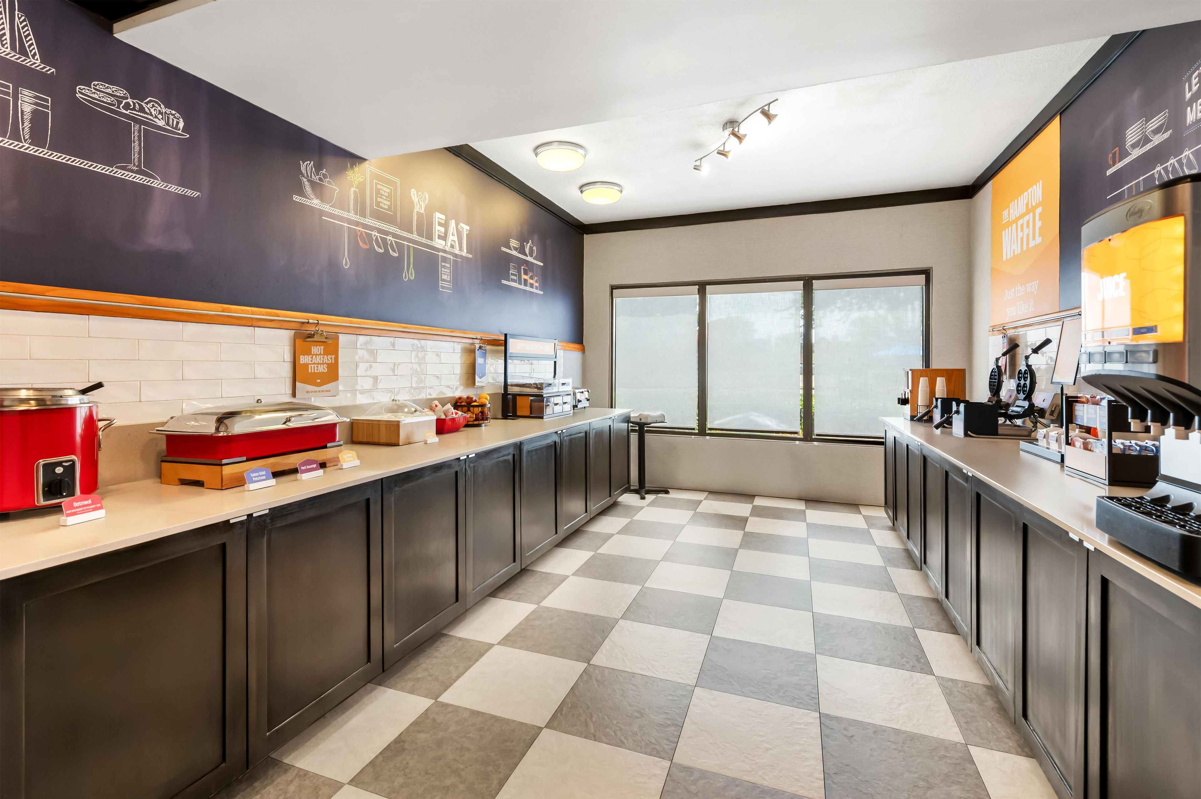 A modern kitchen with a checkered floor, a coffee machine, and a breakfast bar.