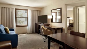 A hotel room with a large bed, a desk with a chair, a television, and a window with curtains. - Hampton Inn & Suites Springdale (Springdale)