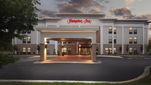 A Hampton Inn hotel entrance with a covered walkway, brick facade, and multiple windows. - Hampton Inn Youngstown/Boardman (Poland)