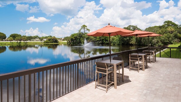 A patio with outdoor seating and a view of a lake. - Hampton Inn Bonita Springs/Naples-North (Bonita Springs)