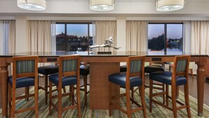 A hotel room with a large dining table, six chairs, and three pendant lights. - Hampton Inn Bonita Springs/Naples-North (Bonita Springs)