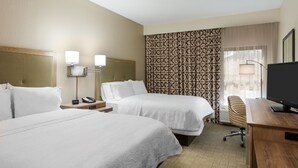 A hotel room with two beds, a desk, a TV, and a patterned wall. - Hampton Inn Bonita Springs/Naples-North (Bonita Springs)