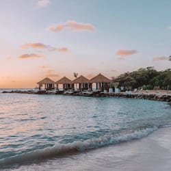 Enjoy ocean views from the beachfront structures, featuring lounge chairs for relaxation.