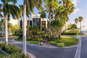 A modern hotel with a central courtyard surrounded by palm trees and greenery.