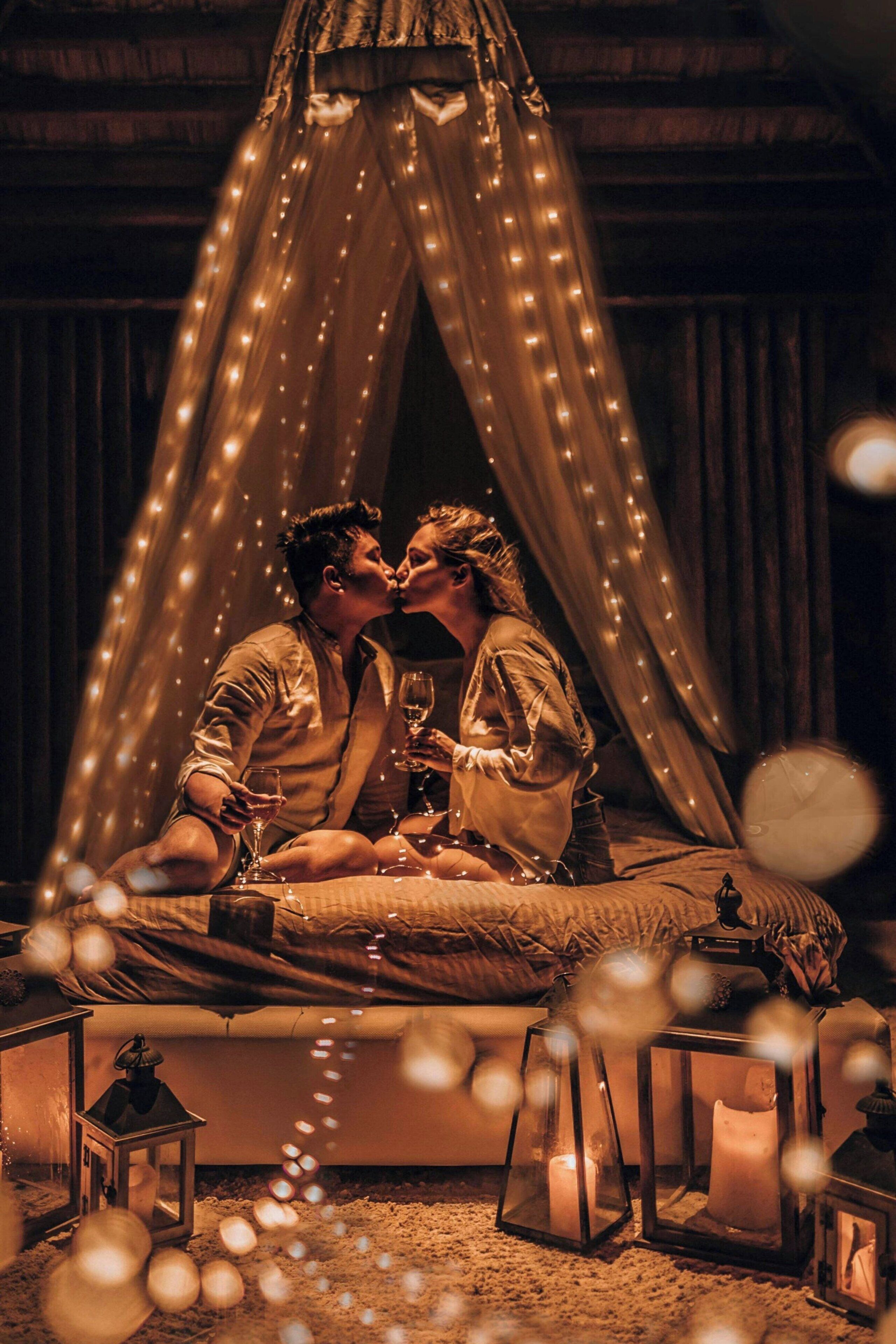 Una pareja en un área con carpas, luces colgantes, velas y faroles.