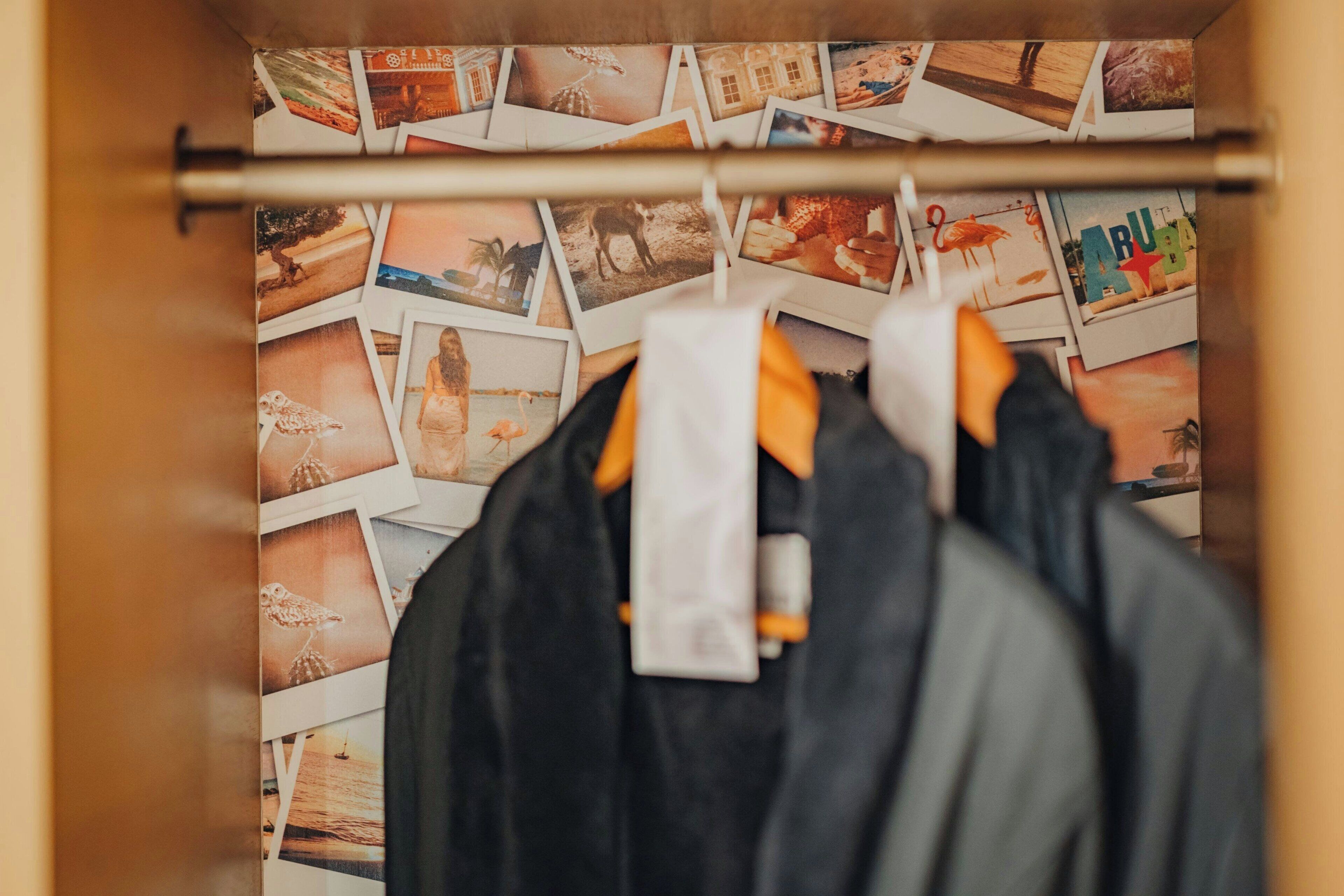 Un placard rempli de vêtements et un mur décoré de photos.