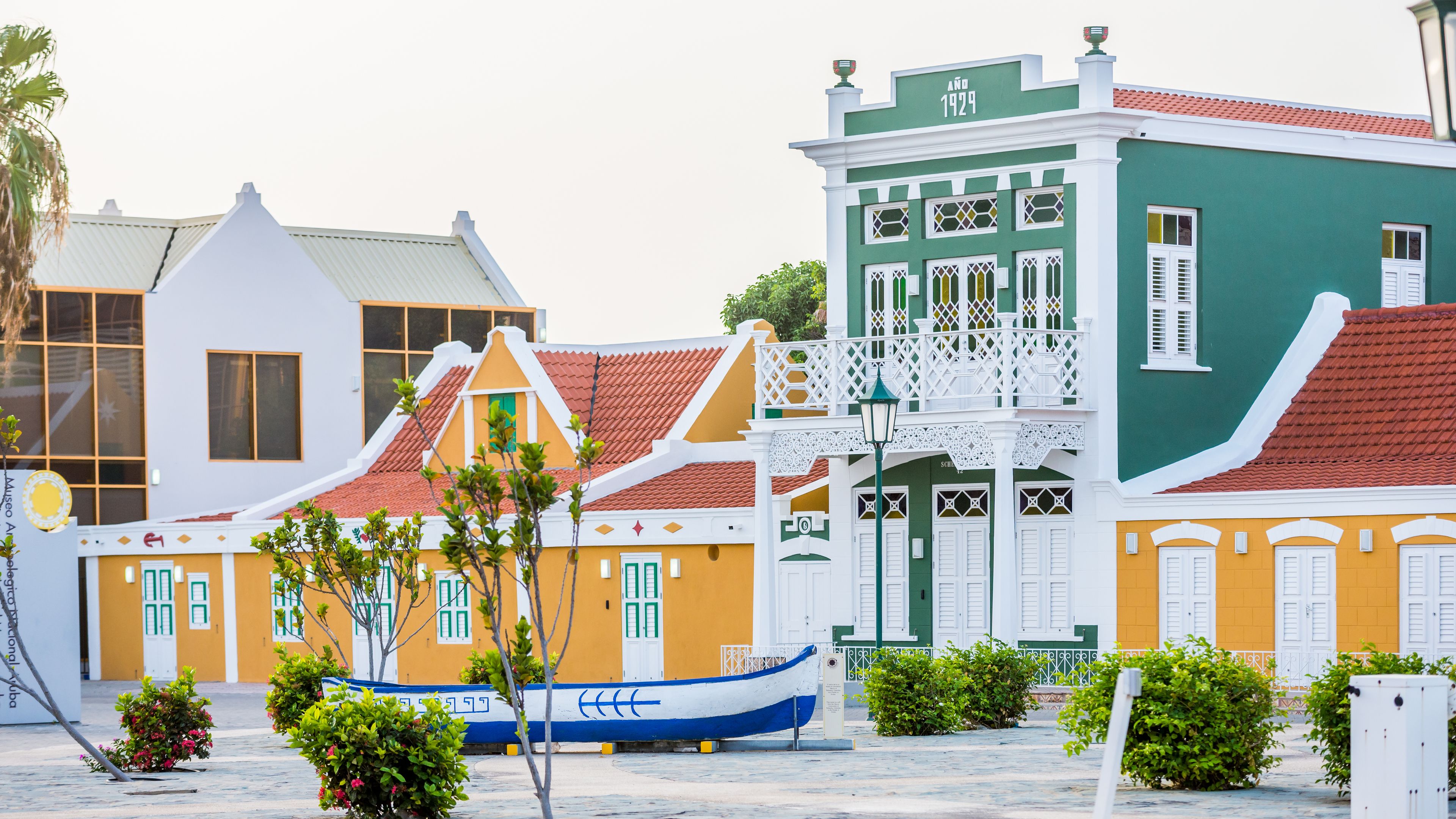 Un bâtiment aux couleurs vives, avec une façade verte et un toit recouvert de tuiles rouges.