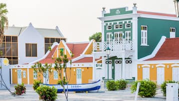 Un bâtiment aux couleurs vives, avec une façade verte et un toit recouvert de tuiles rouges.