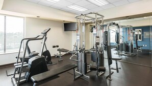 A gym with exercise equipment, a bench, and a mirror. - Comfort Suites Baymeadows Near Butler Blvd (Jacksonville)