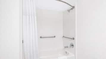 A bathroom with a shower, a sink, and a towel rack.