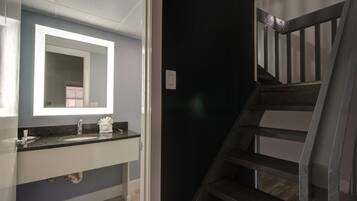 A bathroom with a sink, mirror, and towel rack.