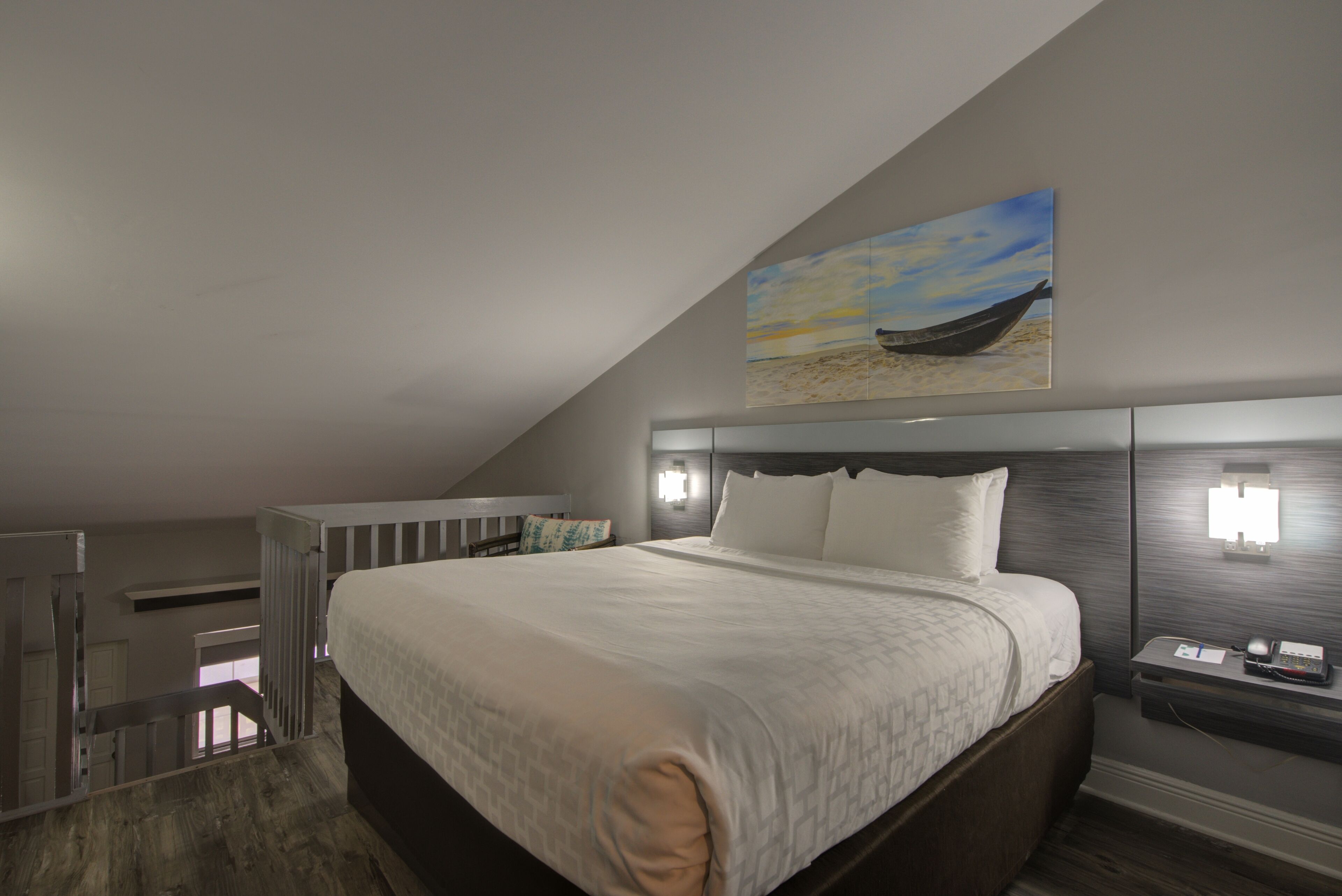 A bedroom with a large bed, a nightstand, a wall-mounted lamp, and a painting of a boat on the ceiling.