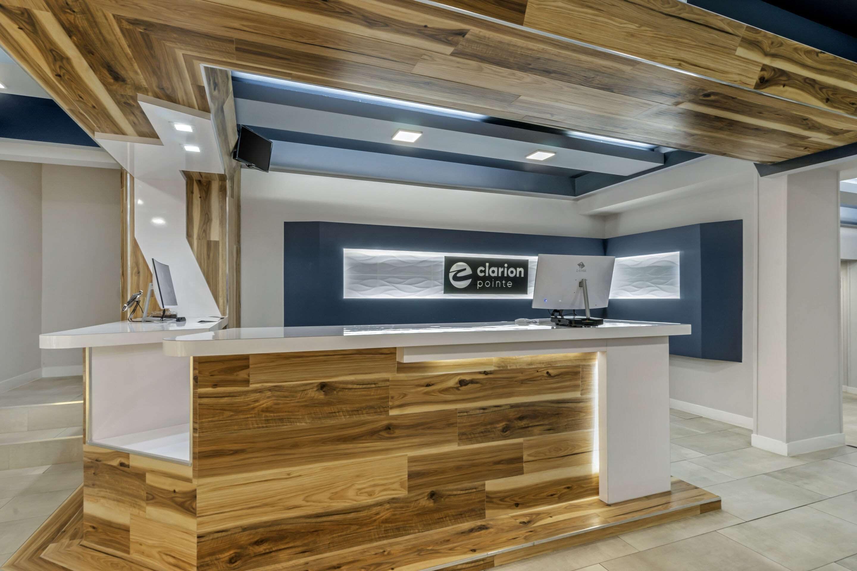 A reception desk with a wooden finish and a sign that reads "clarion pointe".