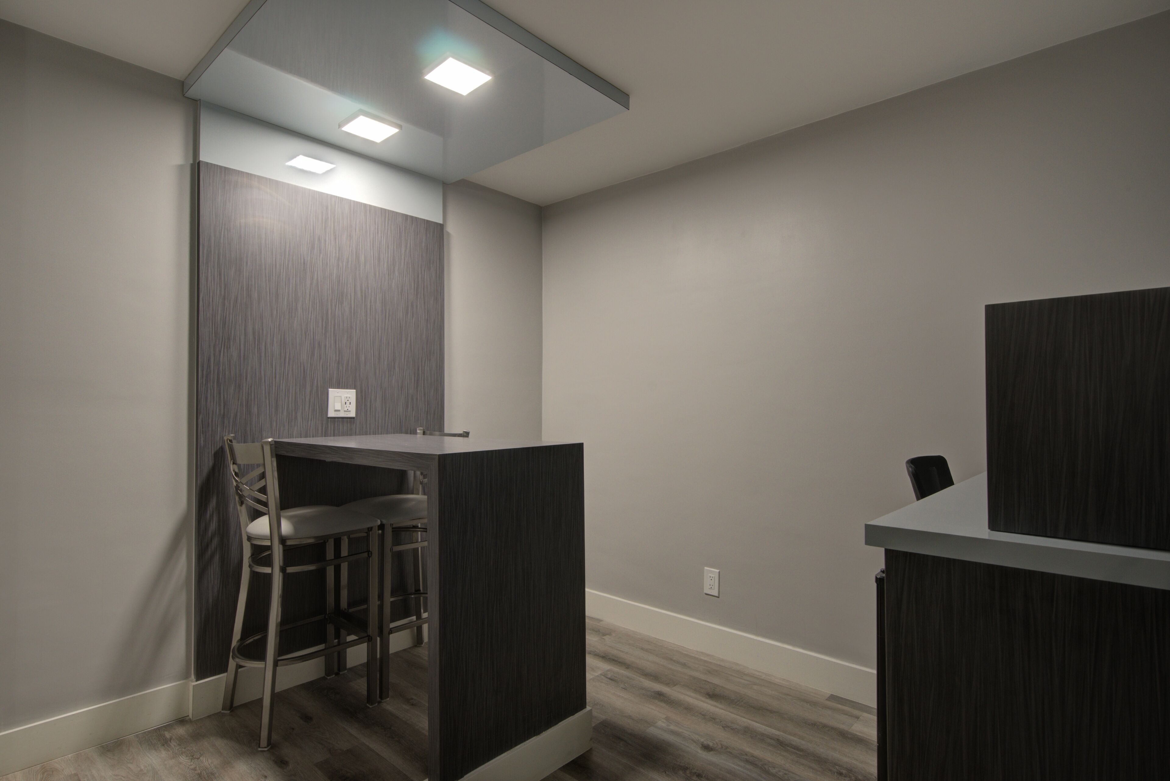 A modern office space with a desk, chair, and cubicle partitions.