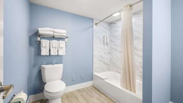 A bathroom with a toilet, a sink, a bathtub, and a shower curtain.