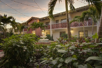 A courtyard with a central fountain, surrounded by palm trees and a swimming pool. at Clarion Pointe Tampa-Brandon Near Fairgrounds and Casino