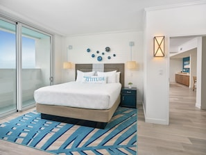 A modern hotel room with a large bed, a view to the outside, a small desk, and a bathroom visible through an open door. - Margaritaville Lake Resort, Lake Conroe/Houston (Montgomery)
