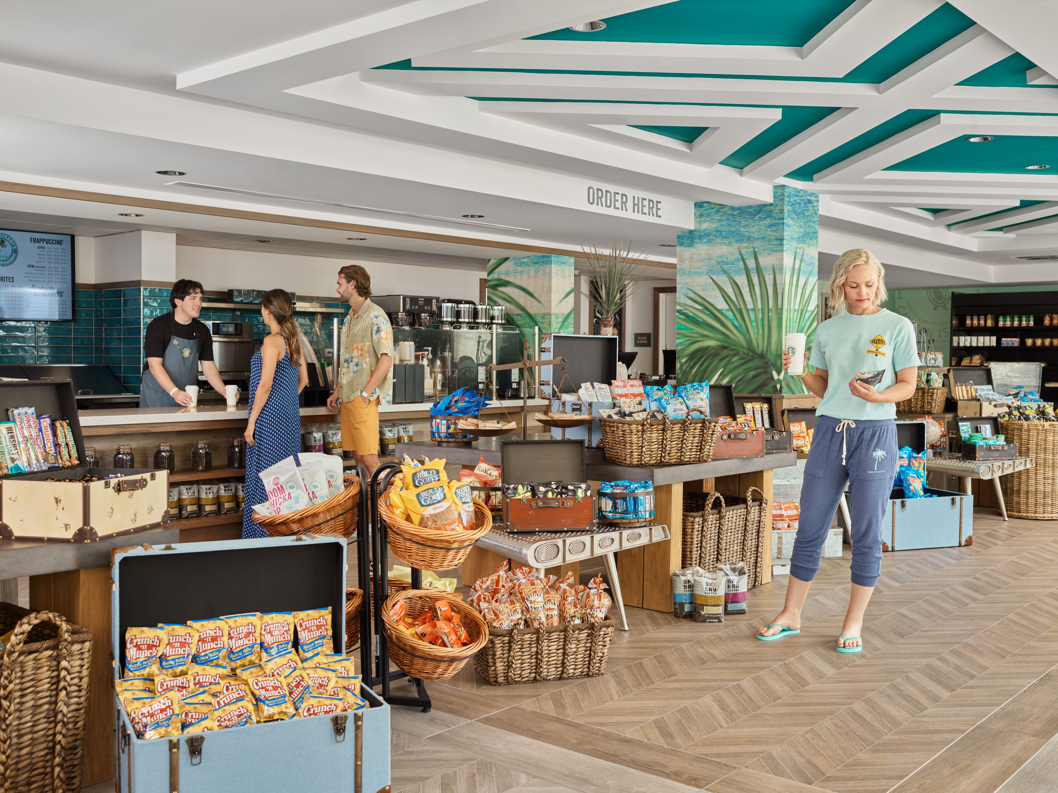 A modern interior with a counter, baskets of snacks, and a sign that says "ORDER HERE".