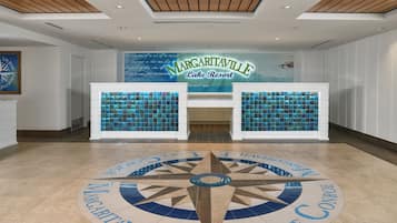A reception area with a large sign reading "Margareville Lake Resort" and a circular floor design with "Margareville Lake" and "Lake Conway" inscribed.