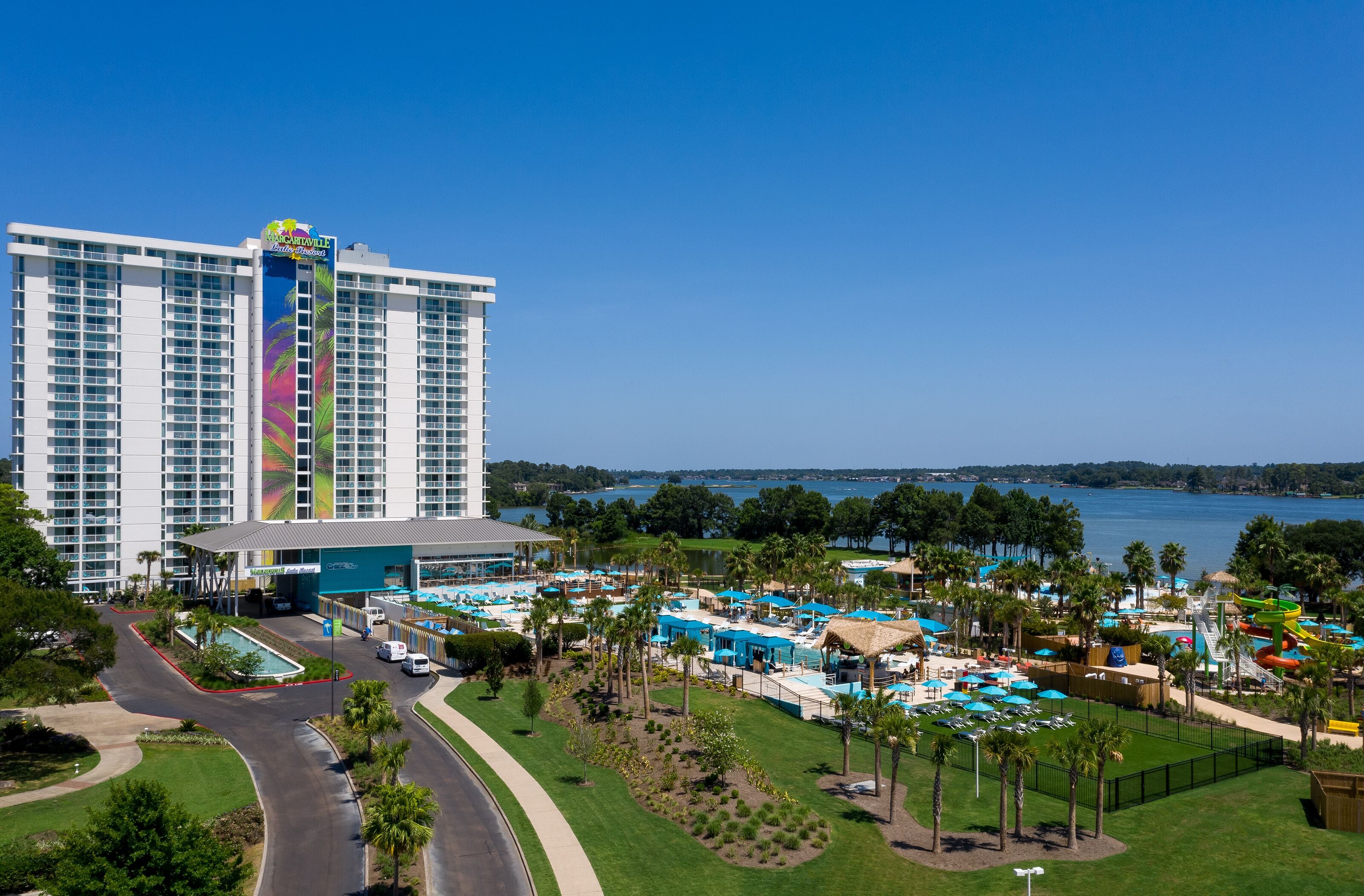Un hotel grande con zona de piscina, parque acuático y vistas al lago.