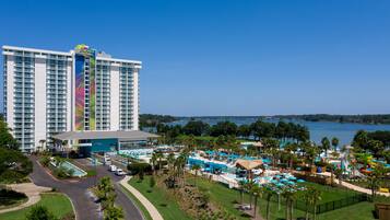 Un hotel grande con zona de piscina, parque acuático y vistas al lago.