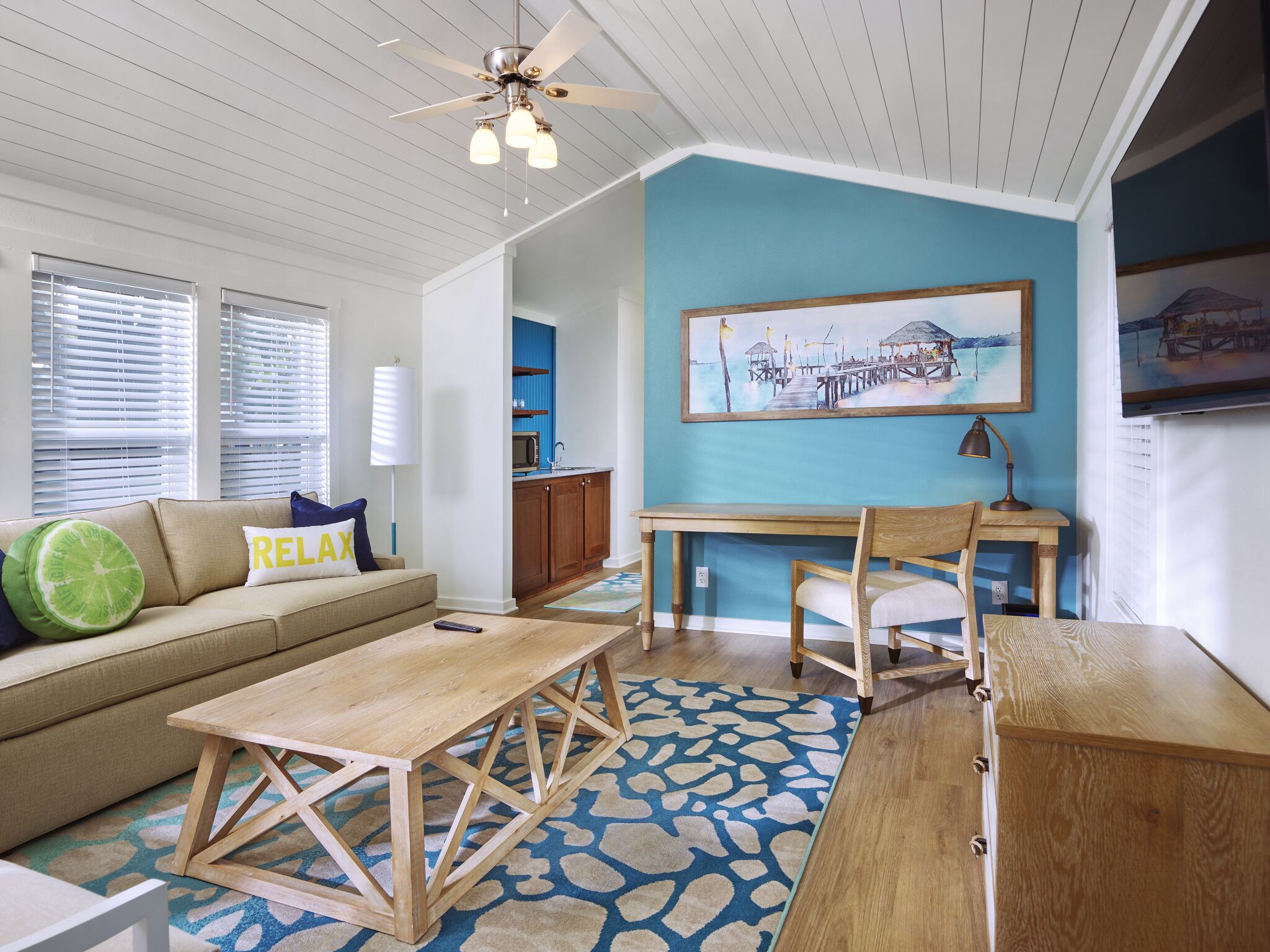 A living room with a sofa, coffee table, and a painting on the wall.